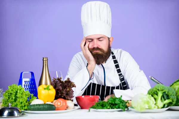 Culinary inspiration. Hard day at restaurant. Tired and exhausted chef. Man bearded chef cooking food. Chef fed up of boring meals. Looking for inspiration. Bored chef lean on table at kitchen