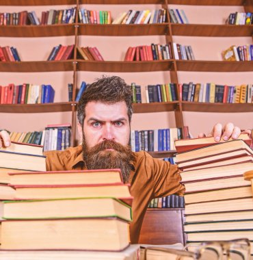 Öğretmen ya da öğrenci sakallı defocused gözlük ile masada oturur. Adam Kitaplığı'nda, eğitim sırasında kitaplar, kitap rafı arka plan üzerinde yığınları arasında sıkı yüzünde. Kazık kavramı