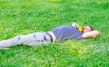 Sakal karahindiba çiçeklerle sakallı adam çayır, çimen arka plan üzerinde yatıyordu. Bahar kavramı. Hippi sakal rahatlatıcı dandelions buket. Sakallı yüzü uyku üzerinde zevk bahar