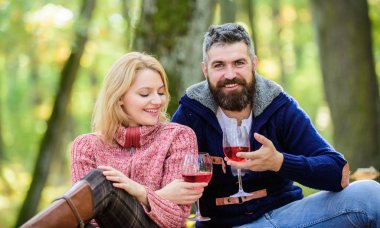 Mutlu sevgi dolu çift birlikte parkta rahatlatıcı. Ormanda şarapla romantik piknik. Aşık çift yıldönümü piknik tarihini kutluyor. Mükemmel randevularının tadını çıkarıyorlar. Çift sarılma içme şarap