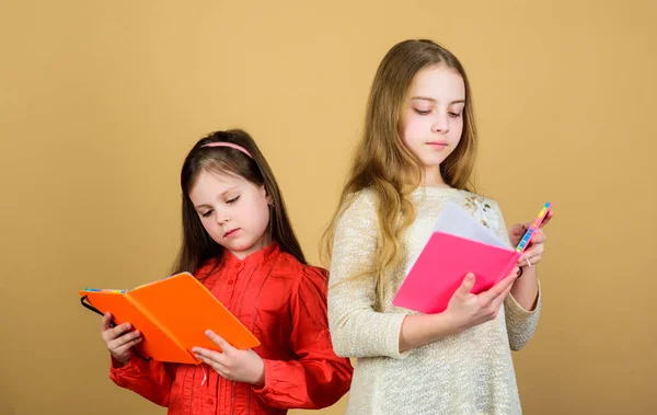 Παιδιά με βιβλία ή διαφημιστικά. Εκπαίδευση και παιδική λογοτεχνία. Αγαπημένο παραμύθι. Οι αδελφές κάνουν βιβλία για να διαβάσουν μαζί. Αξιαγάπητα κορίτσια λατρεύουν τα βιβλία. Μυστικό ημερολόγιο. Άνοιγμα θυρών μέσω αλφαβητισμού — Φωτογραφία Αρχείου