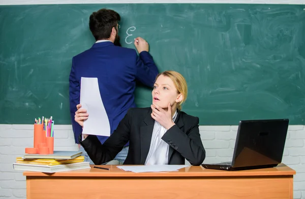 Educación escolar. Prepárate para la clase escolar. Revisa los deberes. Anota tu tarea. Profesores que trabajan en parejas en el aula escolar. Educador escolar y profesor en prácticas con documentos. Programa educativo — Foto de Stock