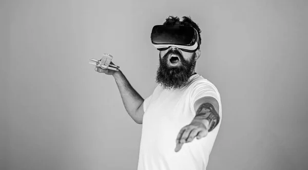 Hipster no rosto gritando desfrutar de jogar jogo na realidade virtual. Homem com barba em óculos VR, fundo azul claro. Conceito de jogador VR. Cara com cabeça montada exibição e espada jogar jogo de luta em VR — Fotografia de Stock