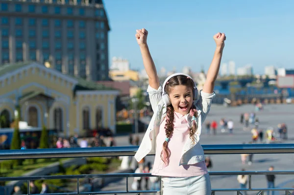 Girl little tourist kid explore city using audio guide application. Free style of travelling. Exciting journeys through cities and museums. Audio tour headphones gadget. City guide and audio tour