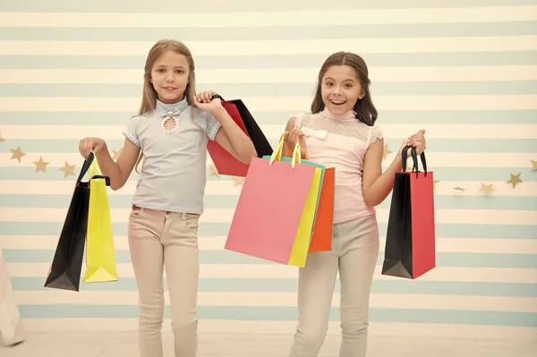 女の子らしい幸福。幸せな子供は、束のパッケージを運ぶ。最高の友人概念と買い物に。ショッピングのような女の子。子供たちの幸せな小さな女の子は、買い物袋を保持します。親友や妹とショッピングをお楽しみください。 — ストック写真