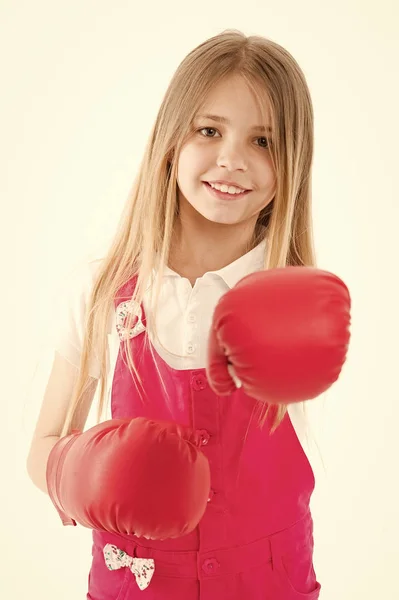 Girls power concept. Girl on smiling face posing with boxing gloves, isolated on white background. Girl likes boxing and sporty lifestyle. Kid girl with long hair knows how to defend herself