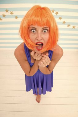 Kırmızı leydi ya da mavi elbiseli kızıl peruk. Çizgi roman oyuncusu konsepti. Kadın neşeli ruh hali eğleniyor. Eğlence ve eğlence. Kadın oyuncu performans çalışıyor. Stüdyonun çizgili arka planı