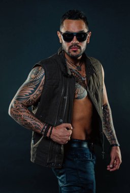 Sakal ve gözlük tıraşsız yüzündeki ile dövme modeli. Maço güçlü kol dövme ile. Trendy kıyafetler dövmeli kas adam. Güven ve karizması ile moda atlet. Moda stil ve eğilim