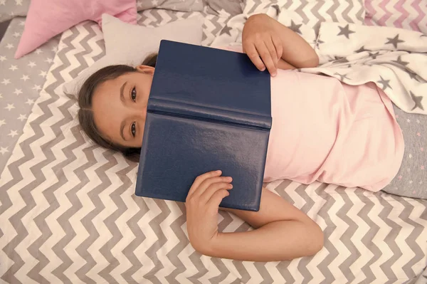 Kız çocuk kitap en iyi görünüm okuma yatakta yatıyordu. Çocuk yatmaya hazırlanın. Keyifli zaman rahat yatak odasında. Kız çocuk rahatla ve kitap okumak. Okuma ve memnun mutlu son ile tamamlandı. Okuma becerilerini geliştirmek — Stok fotoğraf