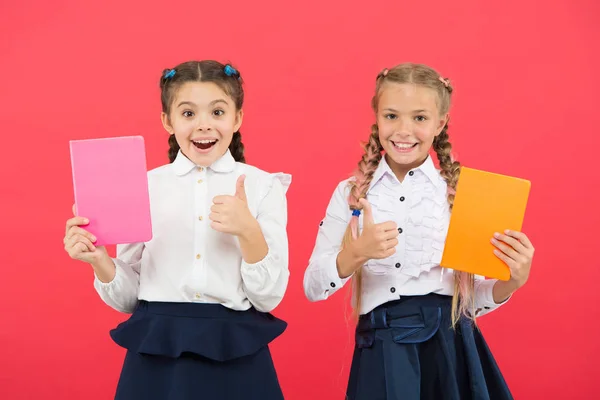 Acheter de la papeterie mignonne pour étudier amusant. Filles célèbres pour l'obsession de la papeterie. Les filles enfants uniforme scolaire tiennent le livre. Écolière montrer carnet notepad.School fournitures concept. Papeterie scolaire — Photo