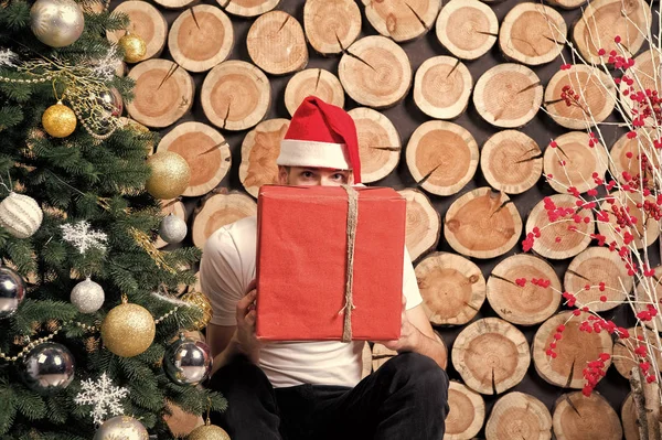 Santa hombre en rojo sombrero peep sobre presente caja — Foto de Stock