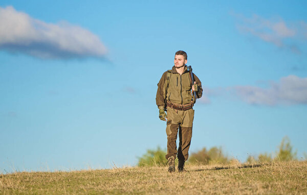 Guy hunting nature environment. Masculine hobby activity. Man hunter carry rifle blue sky background. Experience and practice lends success hunting. Hunting weapon gun or rifle. Hunting hobby