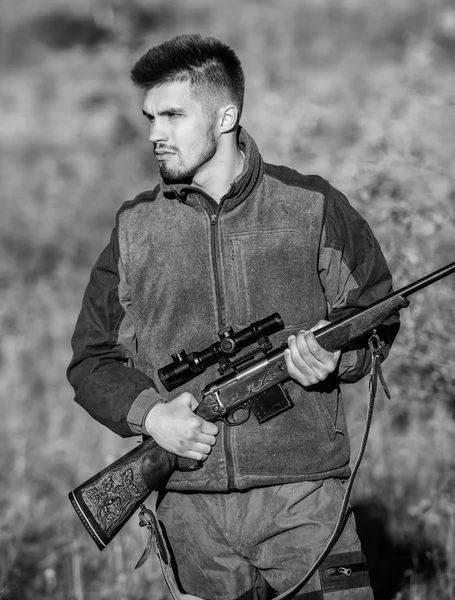 Hunting and trapping seasons. Bearded serious hunter spend leisure hunting. Man brutal unshaved gamekeeper nature background. Hunting permit. Hunter hold rifle. Hunting is brutal masculine hobby
