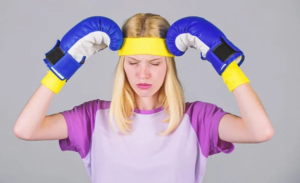 Mantenga la calma y deshacerse del dolor de cabeza. Beat dolor de cabeza. Guantes de boxeo de chicas cansadas de pelear. Una mujer fuerte sufre dolor. Chica cara dolorosa abrazar la cabeza con guantes de boxeo. Remedios para dolor de cabeza. Concepto de dolor de cabeza —  Fotos de Stock