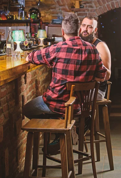 Strong alcohol drinks. Opening hours till last visitors. Friday relaxation in bar. Men relaxing at bar. Friends relaxing in bar or pub. Hipster bearded man spend leisure with friend at bar counter