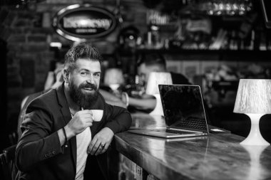 Adam işadamı sit bar counter dizüstü bilgisayar ve kahve sakallı. İçerik web günlüğü oluşturun. Yöneticisi oluşturmak sonrası kahve keyfini çıkarın. Hipster freelancer iş online içme kahve. Kahve molası kavramı