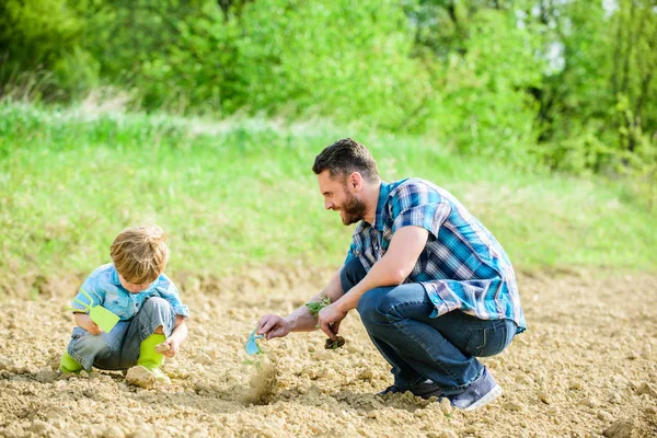 Eco living. happy earth day. Family tree. father and son planting flowers in ground. new life. soils fertilizers. rich natural soil. Eco farm. small boy help father in farming. earth day. earth day