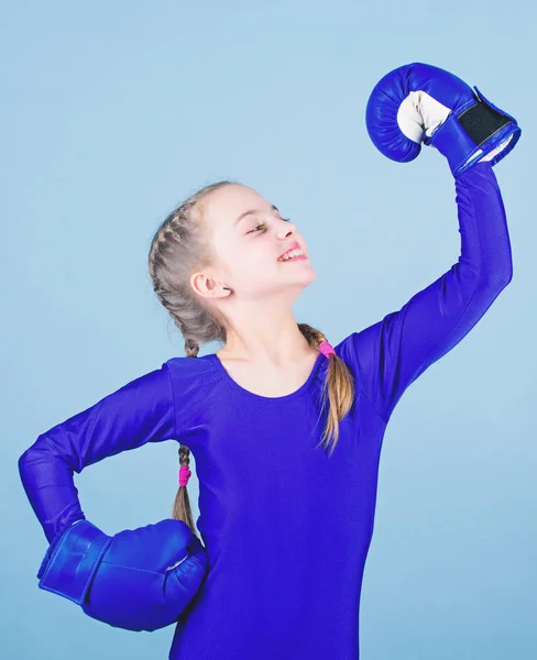 Boxer child in boxing gloves. Rise of women boxers. Female boxer change attitudes within sport. Free and confident. Girl cute boxer on blue background. With great power comes great responsibility