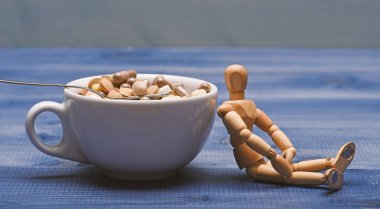 Dokunulmazlık bakım ve tıp vitaminler. İlaçlar karıştırma. Hızlı tedavi. Tıp kavramı al. İlaç dozu. Ahşap insan kukla Kupası tam hapları ve tablet. Vitamini kokteyl. Sağlık sorunu