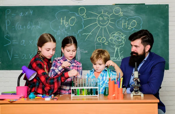 Experimente im Labor oder Chemiekabinett. zurück zur Schule. Chemielabor. Glückliche Kinderlehrerin. Kinder im Laborkittel lernen Chemie im Schullabor. Junge und selbstbewusste Wissenschaftlerin — Stockfoto