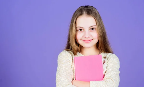 Its her favorite book. Cute small child with text book in hands. Adorable little girl holding exercise book. Self study grammar book, copy space — Stock Photo, Image