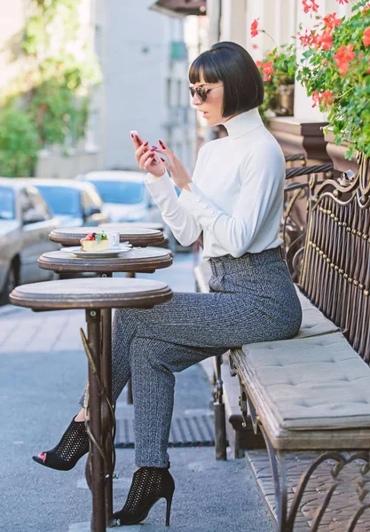 Arkadaş arama. Boş zaman kavramı. Kız moda Bayan smartphone ile. Kadın çekici şık esmer eğlence kafe teras arka plan harcamak. Keyifli zaman ve eğlence. Sakin ol ve kahve molası