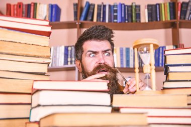 Dostum, bilim adamı kum saati görünüyor. Adam ciddi ve şok yüz izlerken zaman raflardan, arka planda gidiyor. Zaman akışı kavramı. Öğretmen ya da sakal Kitaplığı'nda eğitim ile öğrenci