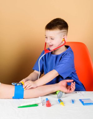 Çocuk sevimli çocuk gelecek doktor kariyer. Sağlık. Çocuk küçük doktor steteskop ve tıbbi aletlerle masaya otursun. Tıp kavramı. Kan basıncını ölçmek. Tıbbi muayene. Tıp eğitimi