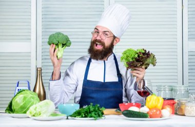 Şapkalı şef adam. Gizli tat tarifi. Sakallı adam mutfakta yemek pişirir, mutfak. Sağlıklı yemek pişirme. Diyet ve organik gıda, vitamin. Vejetaryen. Sakallı olgun şef. Gebelik caprice