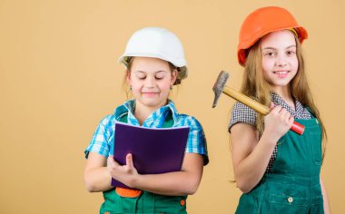 Foreman müfettişi. Tamir et. Mutlu çocuklar. Gelecekteki kariyerim. Tablet ve çekiçle kasklı küçük çocuklar. İşçi bayramı. Olabilir. Küçük kızlar atölyede birlikte tamirat yapıyorlar. Yorgun ve yorucu bir gün.