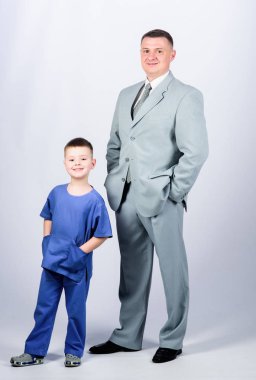 Saygıdeğer bir iş adamı ve küçük çocuk doktor üniforması. Aile işi. Doktor saygın bir kariyer. Baba patron. Baba ve sevimli küçük oğul. Çocuk bakımı gelişimi yetiştirme. Saygın meslek