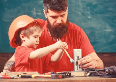 Evlat, Çocuk koruyucu kask yapar elle meşgul tamiri, el sanatları ile baba yok. Sınıfta, arka plan kara tahta araçlarını kullanmak için küçük oğlu öğretim sakallı baba. Mens iş kavramı