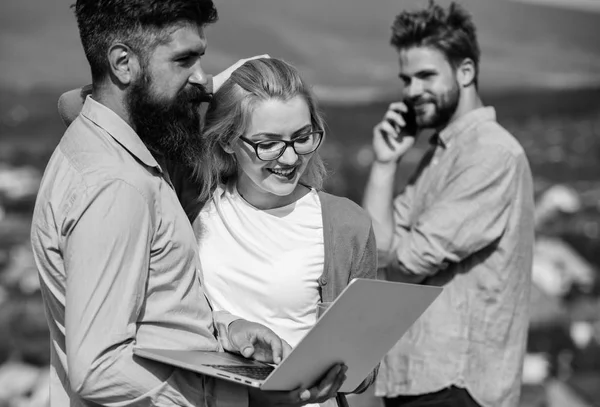 Business partners meeting non formal atmosphere. Colleagues with laptop work outdoor sunny day, nature background. Colleagues pay attention screen laptop while man talking phone. Coffee break concept