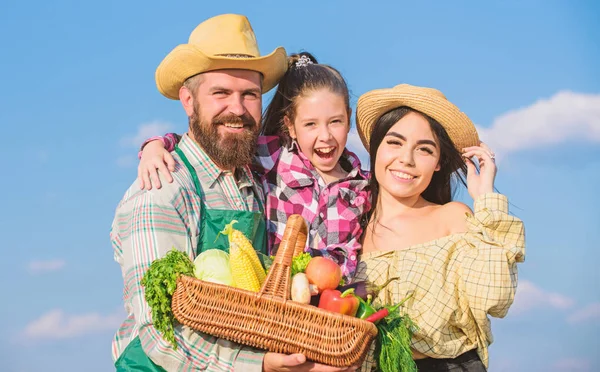 Countryside family lifestyle. Farm market with fall harvest. Man bearded rustic farmer with kid and wife. Family father farmer mother gardener with daughter near harvest. Family farm festival concept