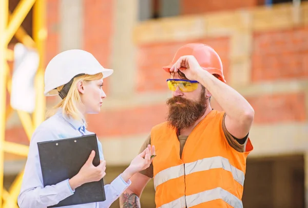 Inspector e construtor brutal barbudo discutem o progresso da construção. Inspecção de projectos de construção. Inspeção de construção, correções e multas. Conceito de inspector de segurança. Discutir o projeto de progresso — Fotografia de Stock