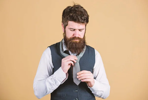 Different ways of tying necktie knots. Art of manliness. How to tie necktie. Start with your collar up and the tie around your neck. How to tie simple knot. Man bearded hipster try to make knot
