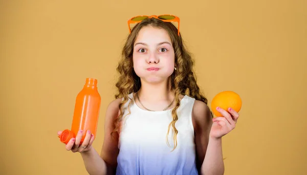 Здравоохранение Летняя витаминная диета. Счастливого детства. Естественный источник витамина. Девочка ест апельсиновые фрукты и пьет апельсиновый сок. Витаминное питание. Детские очки моды пьют освежающий витаминный сок — стоковое фото