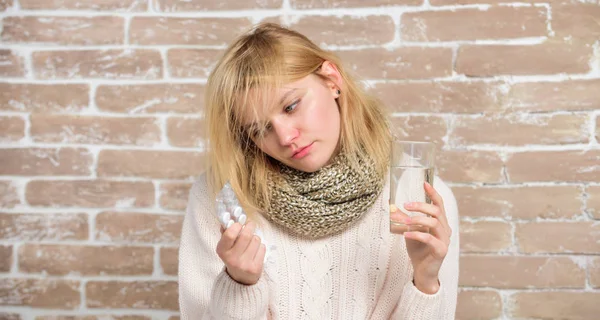 Es tan efectiva la medicina. Una chica enferma tomando píldoras anti-resfriados. Mujer enferma que trata los síntomas causados por el resfriado o la gripe. Mujer malsana sosteniendo pastillas y vaso de agua. Medicamentos y aumento de la ingesta de líquidos — Foto de Stock