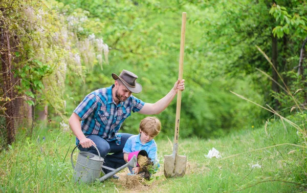 happy earth day. Family tree nursering. watering can, pot and shovel. Garden equipment. Eco farm. small boy child help father in farming. father and son in cowboy hat on ranch. Under the weather