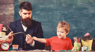 Baba ve oğul birlikte Sanat Merkezi'nde. Baba Çocuk renk seçimi boya fırçaları tutarken. Özel eğitim kavramı
