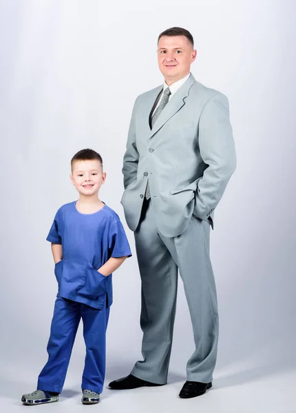 Family business. Doctor respectable career. Dad boss. Father and cute small son. Child care development upbringing. Respectable profession. Man respectable businessman and little kid doctor uniform