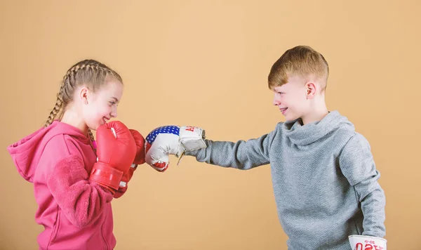 Batalla por atención. Atleta deportivo infantil practicando habilidades de boxeo. Boxeo deportivo. Los niños usan guantes de boxeo mientras luchan contra el fondo beige. Atacar y defender. Chica y chico boxeo competidores — Foto de Stock