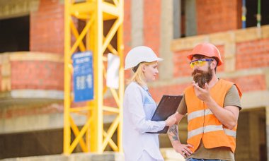 İnşaat endüstri kavramı. İlerleme projeyi tartışmak. Kadın mühendis ve sakallı acımasız builder İnşaat ilerleme tartışmak. İnşaat Proje yönetimi. Bina sanayi projesi