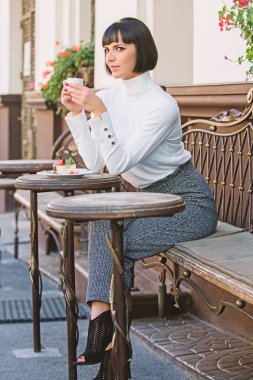 Keyifli zaman ve rahatlama. Delicious ve gurme yemek saati. Kız Cafe kahve ve tatlı ile rahatlayın. Kadın çekici şık esmer tatlı ve kahve Cafe Teras arka plan tadını çıkarın. Tatlı kavramı