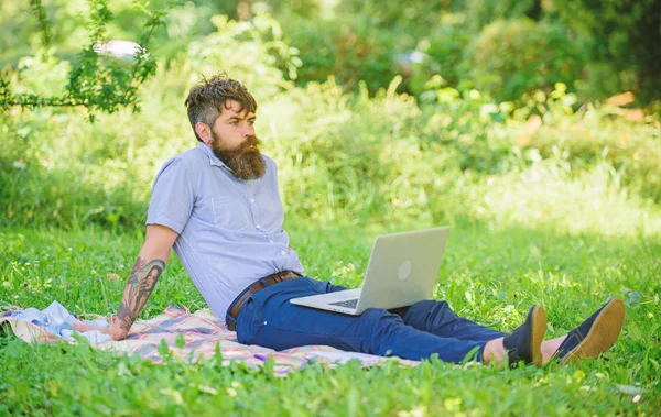 Man bearded with laptop relaxing meadow nature background. Blogger becoming inspired by nature. Writer looking for inspiration nature environment. Inspiration for blogging. Looking for inspiration