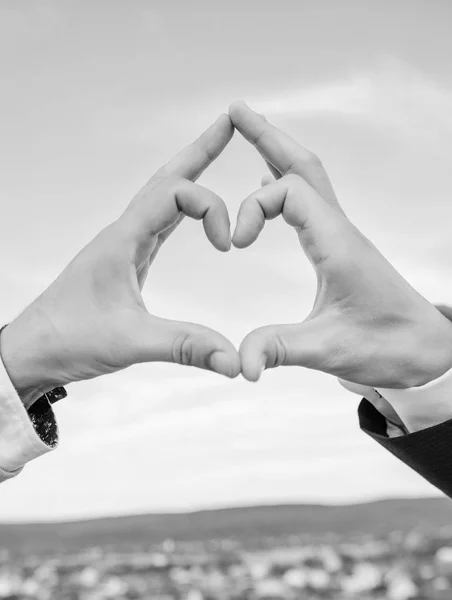 Male hands in heart shape gesture symbol of love and romance. Hand heart gesture forms shape using fingers. Hands put together in heart shape blue sky background. Love symbol concept