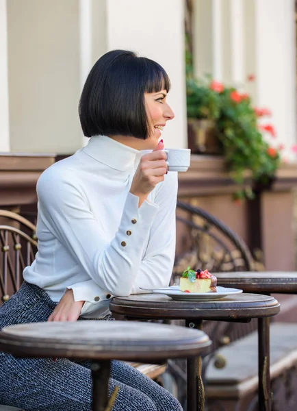 Gourmetkoncept. Hon älskar godis. Kvinna attraktiv elegant brunett äter Gourmet kaka Café terrass bakgrund. Trevlig tid och avkoppling. Läcker gourmettårta. Girl Relax café med tårta dessert — Stockfoto