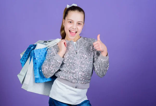 half price. Kid fashion. shop assistant with package. Sales and discounts. Happy child. Little girl with gifts. Small girl with shopping bags. special offer. Holiday purchase saving. half price sale