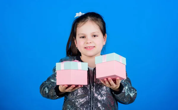 Choose one. Girl with gift boxes blue background. Black friday. Shopping day. Cute child carry gift boxes. Surprise gift box. Birthday wish list. World of happiness. Special happens every day