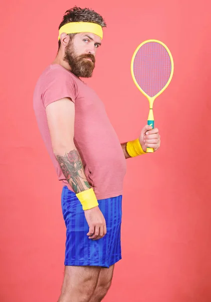 Homem barbudo hipster usar roupa esporte da velha escola com ligaduras. O tênis pode ser uma maneira eficaz de perder peso. Atleta segurar raquete de tênis na mão sobre fundo vermelho. Desporto de ténis. Conceito de clube de tênis — Fotografia de Stock